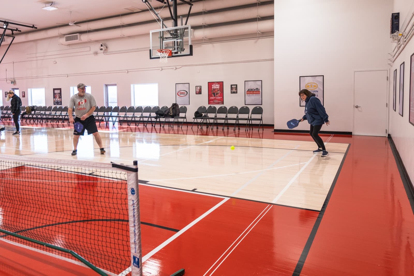 Two Prairie Pickleball members in a rally on the HoopLife Centre floor in Regina
